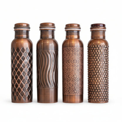 Four copper water bottles with different patterns on a wooden surface and gray background