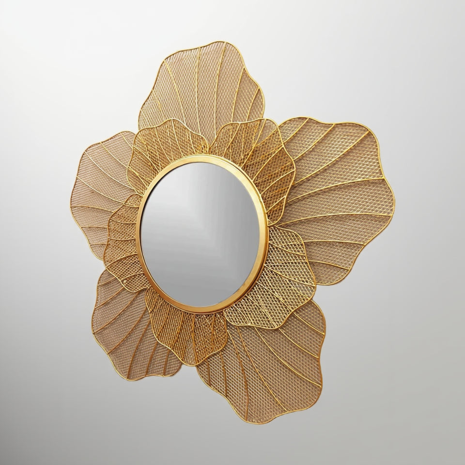 Decorative gold mirror with a floral design on a gray background