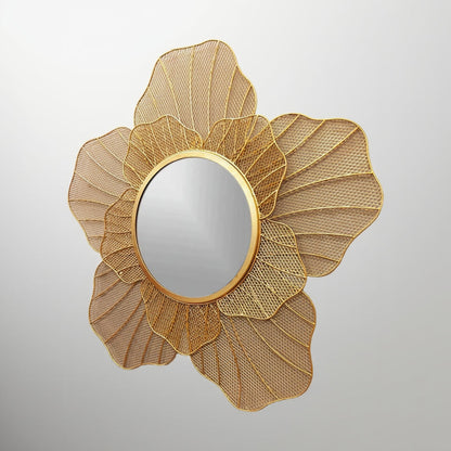 Decorative gold mirror with a floral design on a gray background