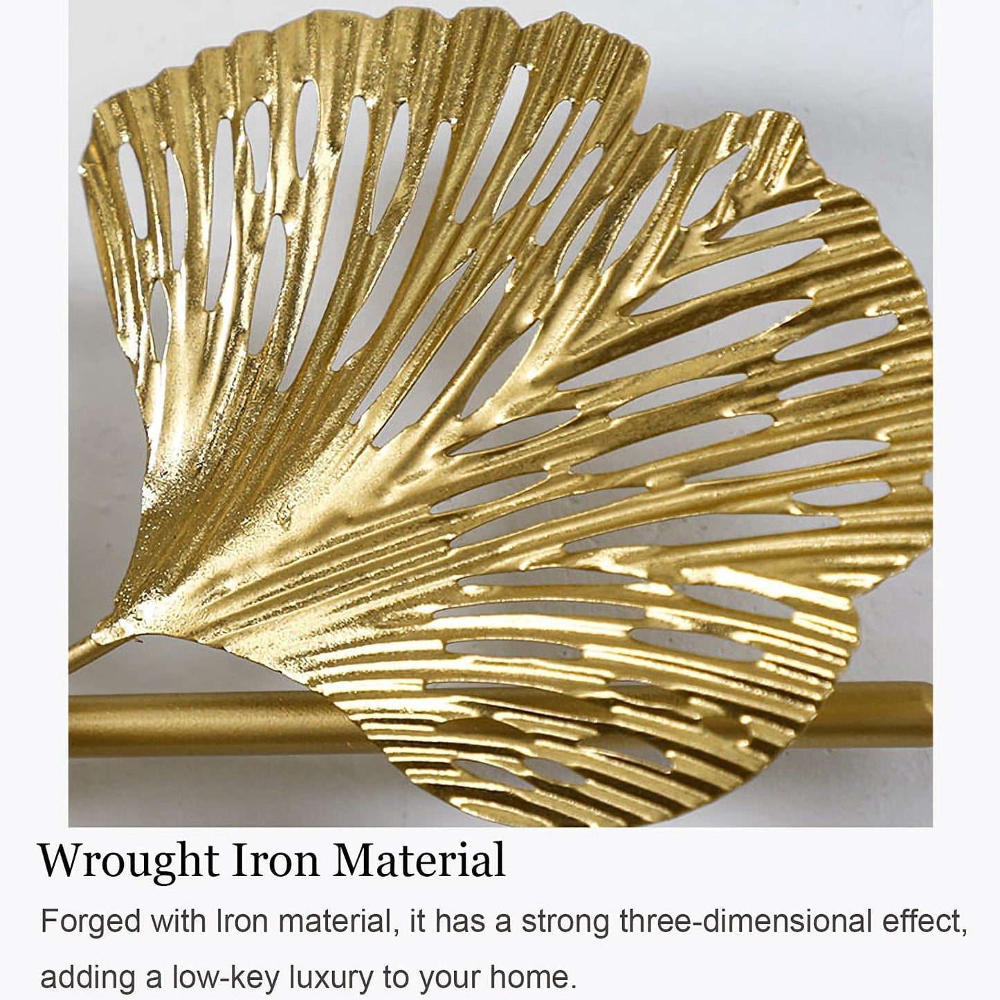 Gold leaf-shaped wall decor with text describing wrought iron material.
