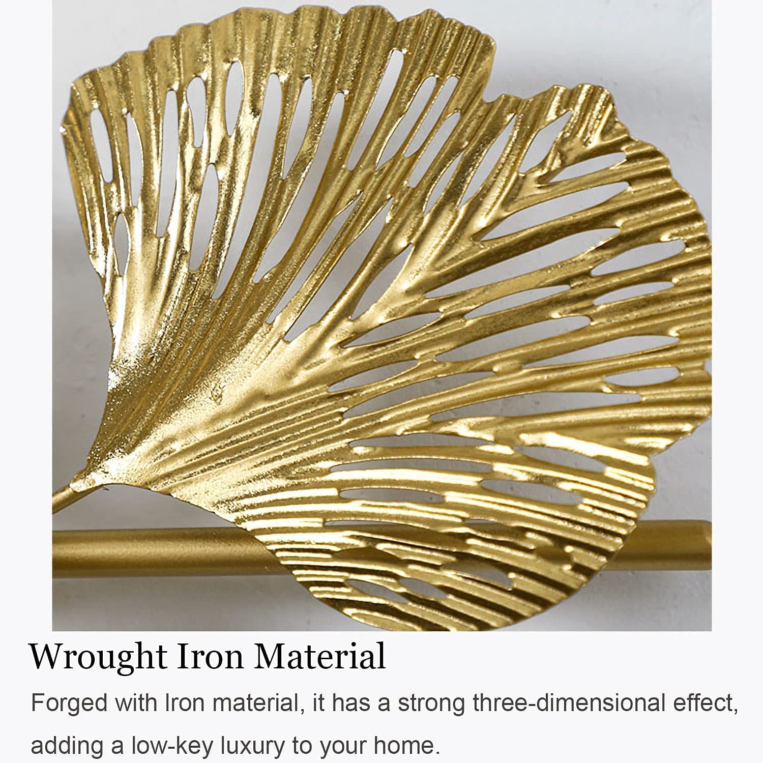 Gold leaf-shaped wall decor with text describing wrought iron material.