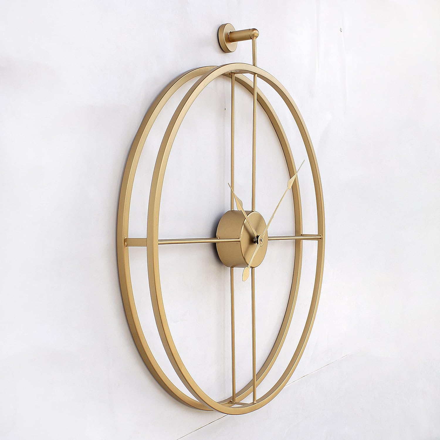 Gold wall clock with a decorative design on a white wall