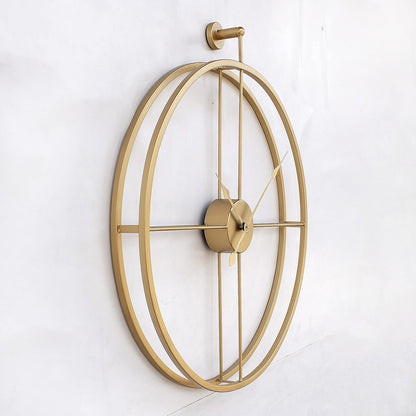 Gold wall clock with a decorative design on a white wall