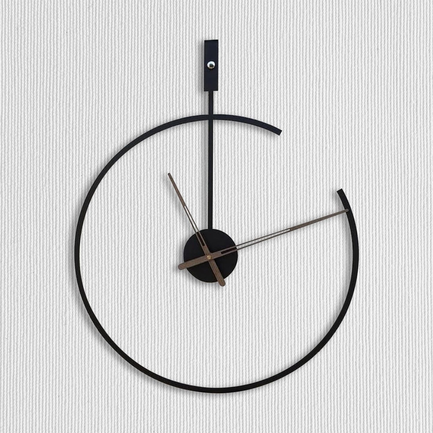 Modern wall clock with black frame and silver hands on a light gray background