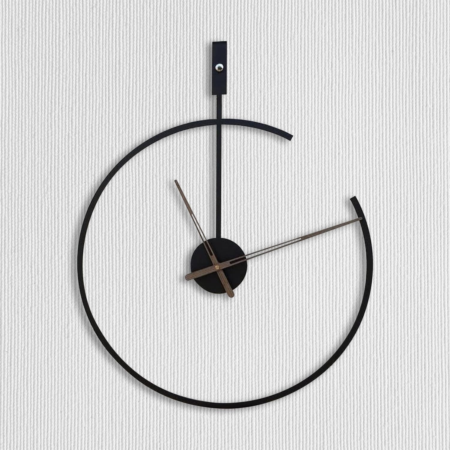 Modern wall clock with black frame and silver hands on a light gray background