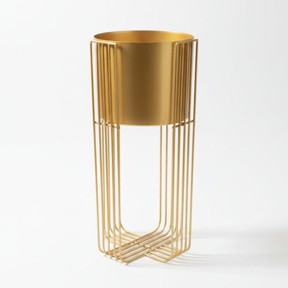 Gold metal plant stand against a textured white wall