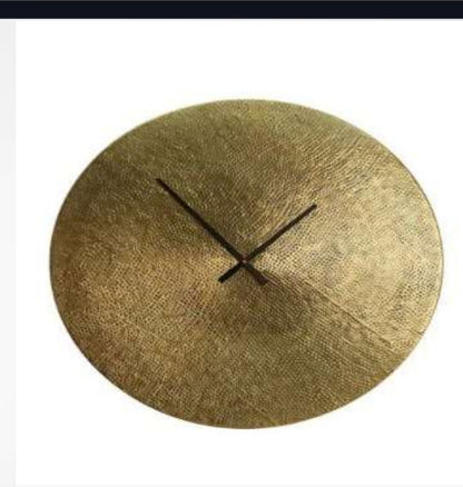 Round gold wall clock with black hands on a white background