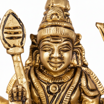 Gold-colored statue of a deity holding a weapon on a white background