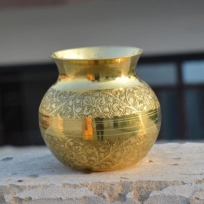 Decorative gold vase with intricate patterns on a stone surface