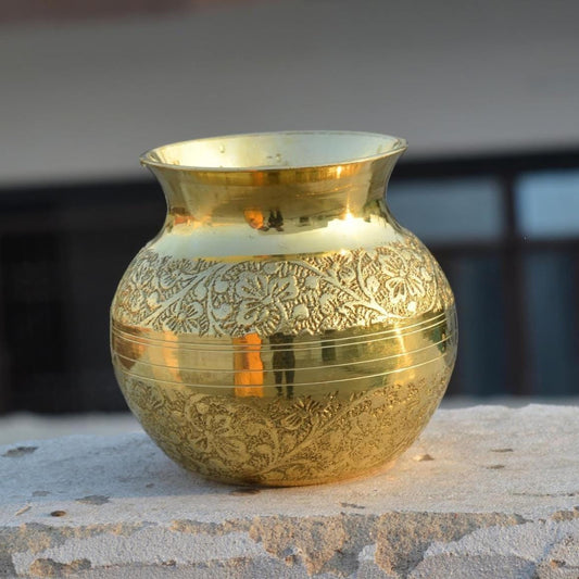 Decorative gold vase with intricate patterns on a stone surface