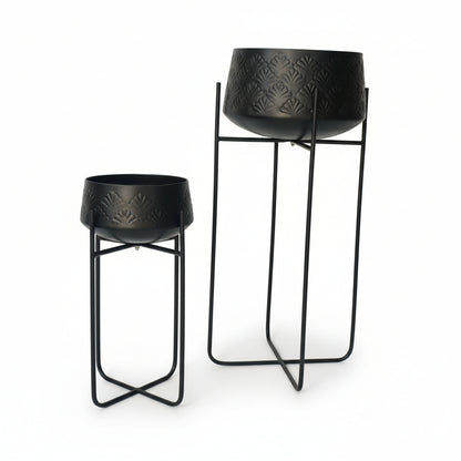 Two black bar stools with textured seats on a white floor.