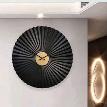 Black wall clock with gold accents on a white wall
