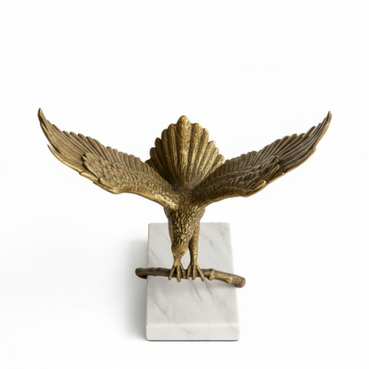 Bronze eagle sculpture on a white marble base against a white background