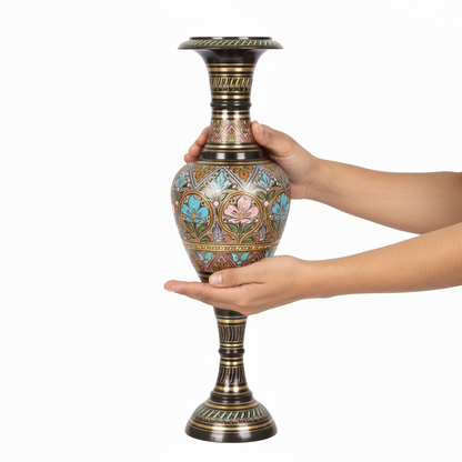 Decorative vase held by a hand on a white background
