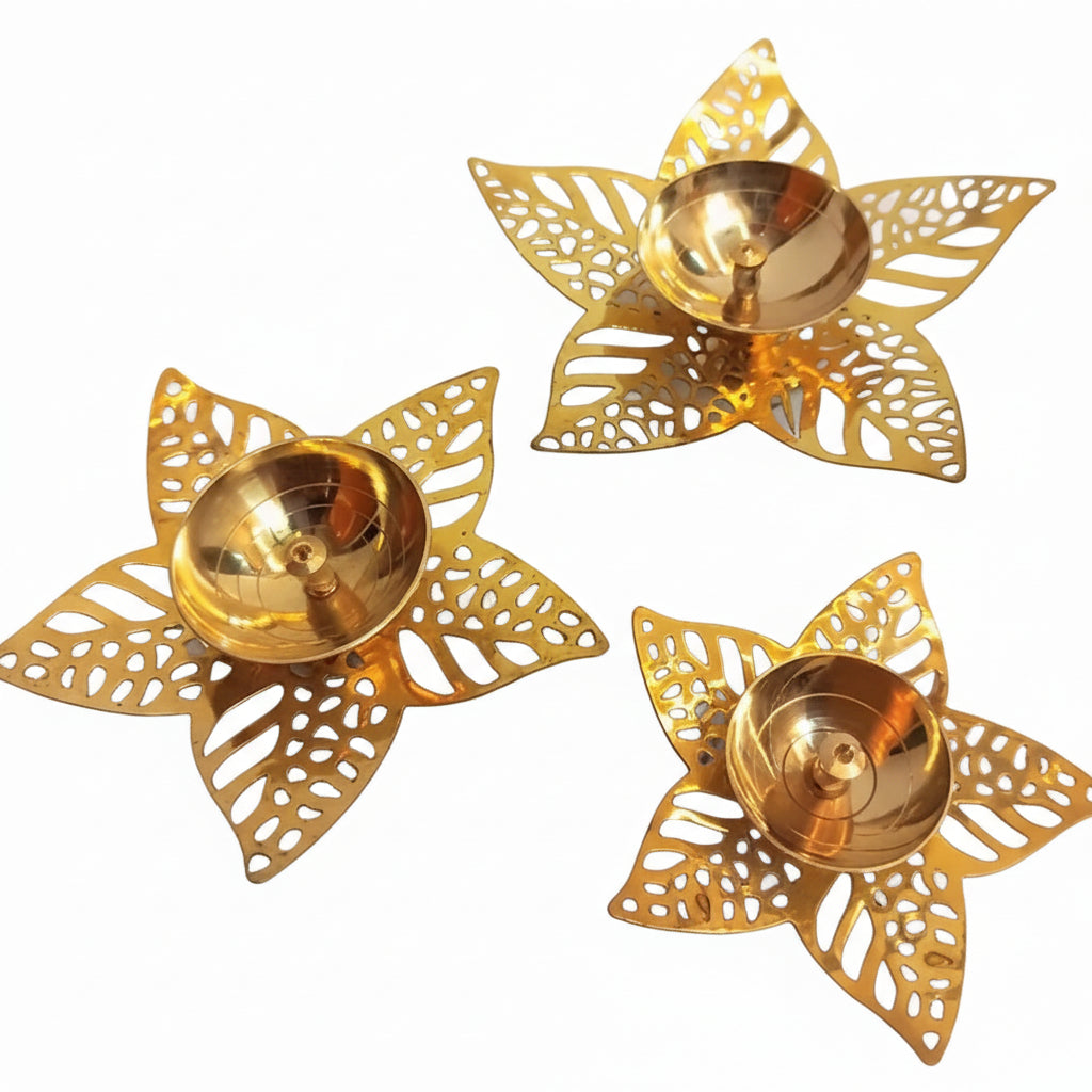 Three gold decorative candle holders on a marble surface
