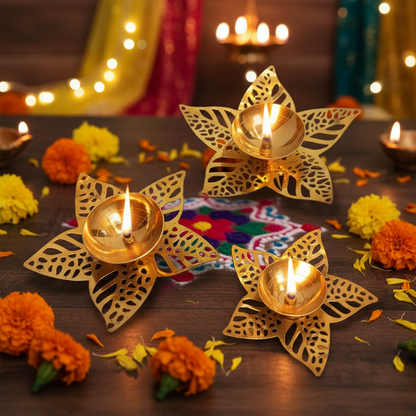 Decorative gold flower-shaped lamps with candles on a wooden table with flowers and lights in the background.