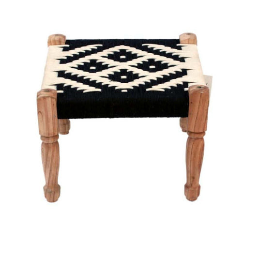 Small stool with a black and white patterned cushion on a white background