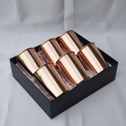 Set of four rose gold cups in a black box on a light gray background