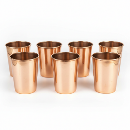 Set of eight copper cups on a white background