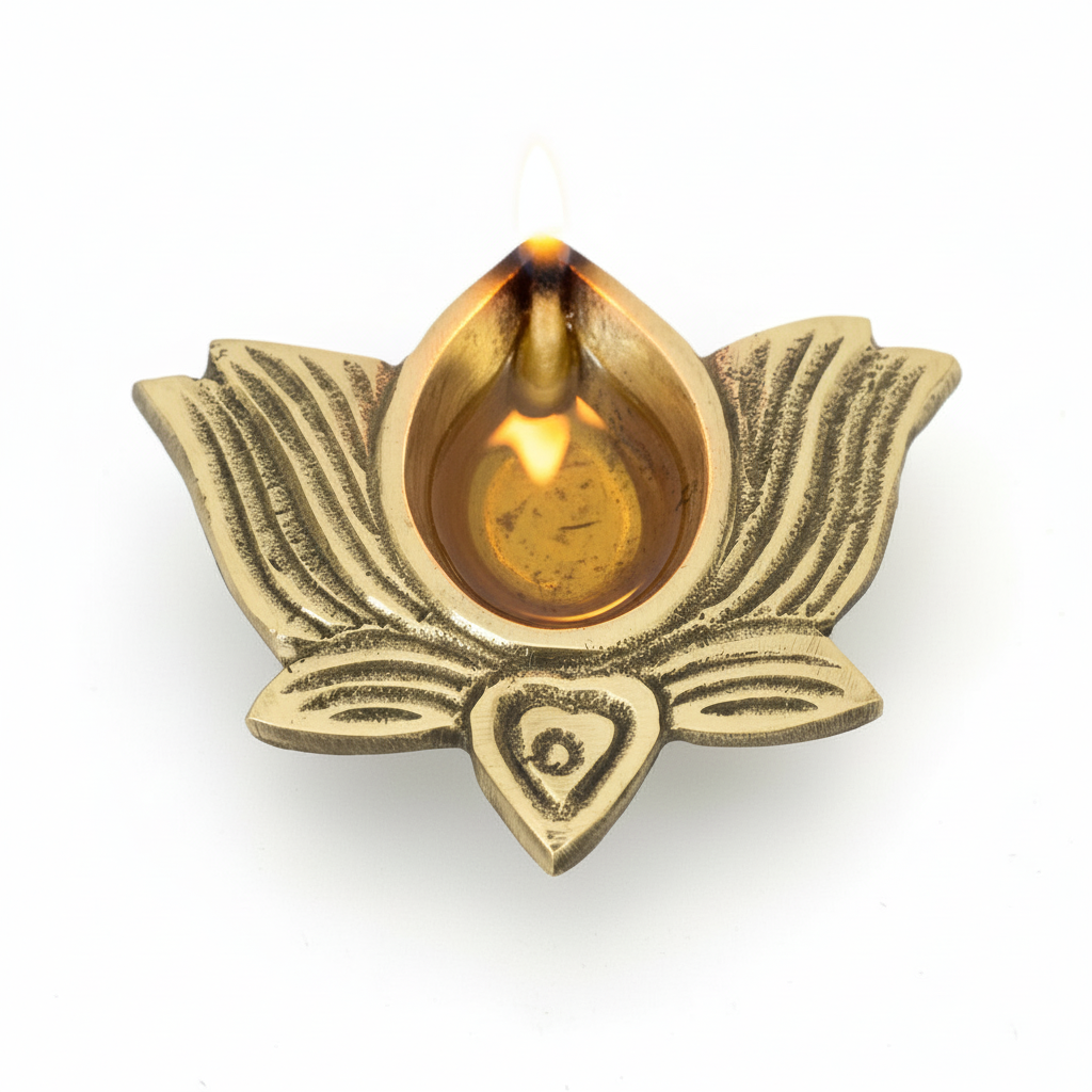 Brass lotus-shaped oil lamp with a lit wick on a white background