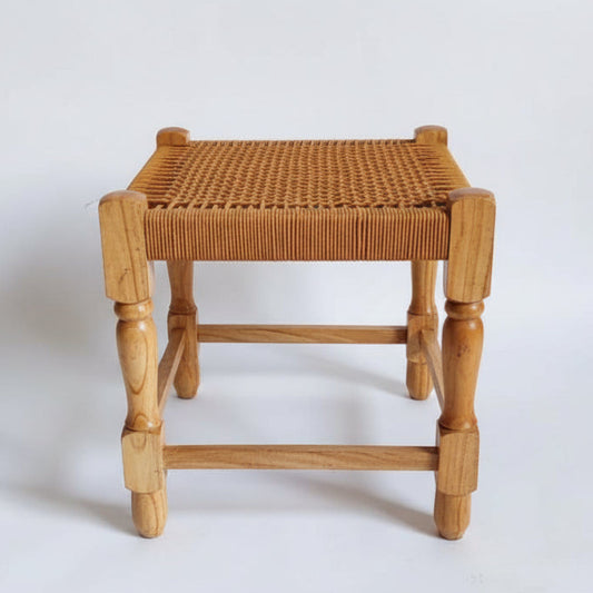 Wicker stool on a marble floor with a light gray wall background