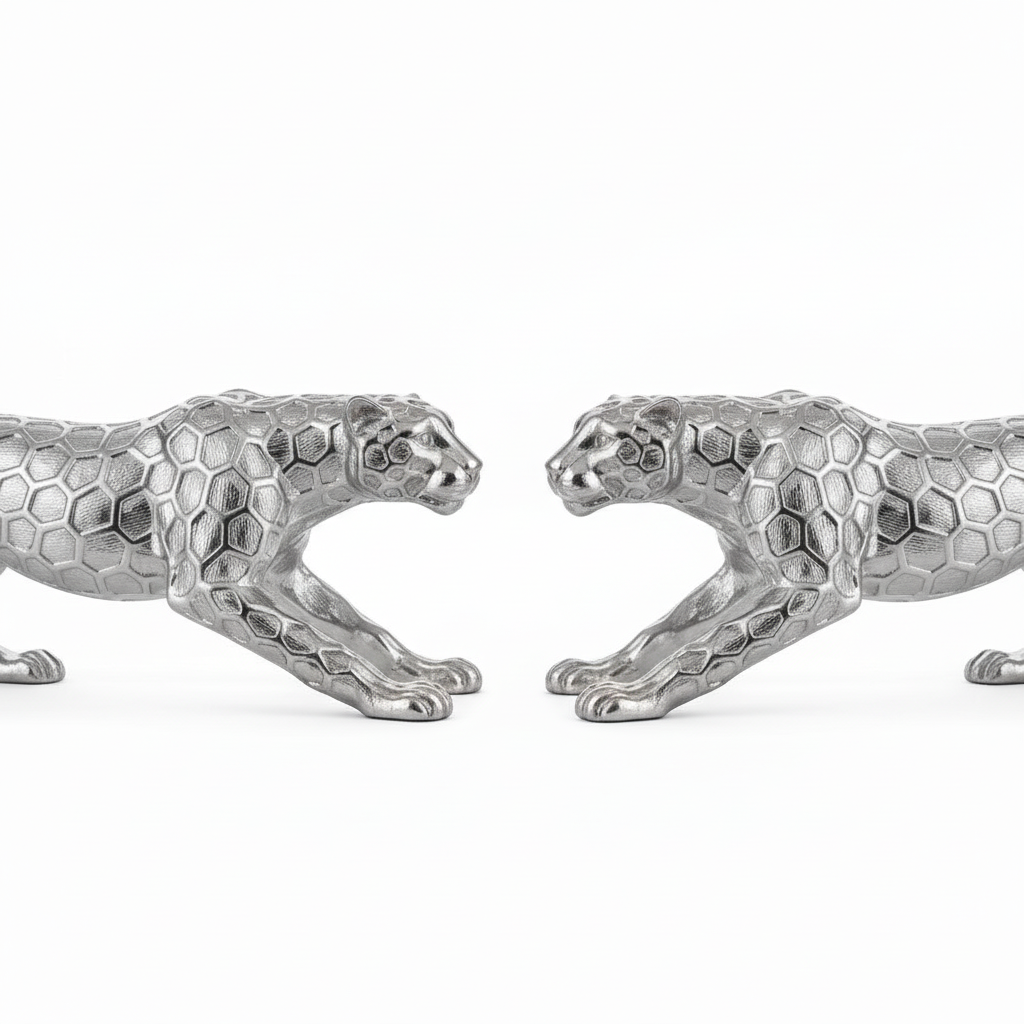 Two silver panther figurines facing each other on a white background
