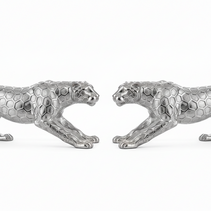 Two silver panther figurines facing each other on a white background