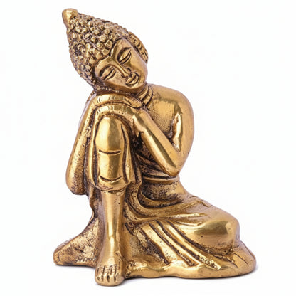 Gold-colored Buddha statue in a meditative pose on a white background