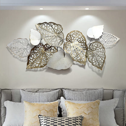 Decorative wall art with leaf patterns above a sofa in a living room.