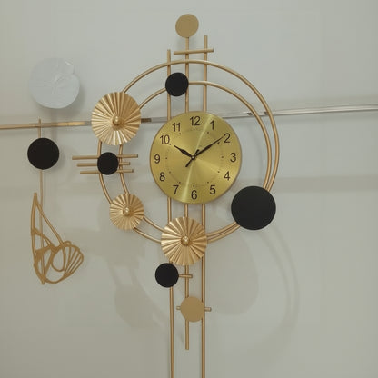 Decorative wall clock with gold and black design on a light background