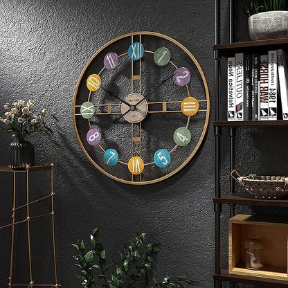 Decorative wall clock with colorful numbers on a dark gray wall, next to a bookshelf and small plant.