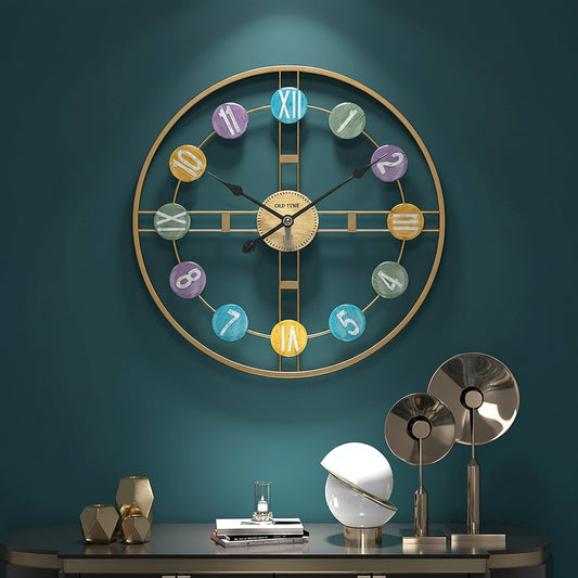 Decorative wall clock with colorful numbers on a teal wall, below a table with decorative items.
