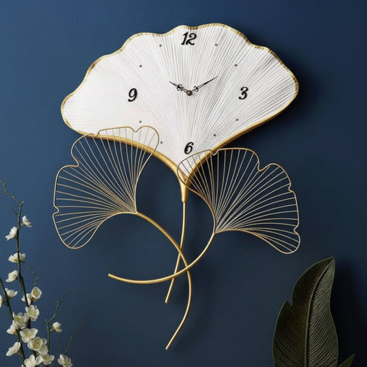 Decorative wall clock with leaf design on a dark blue background