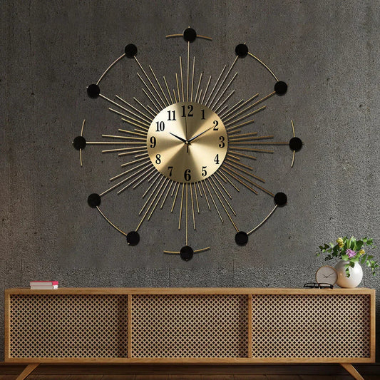 Decorative wall clock with sunburst design on a gray wall above a wooden console table.