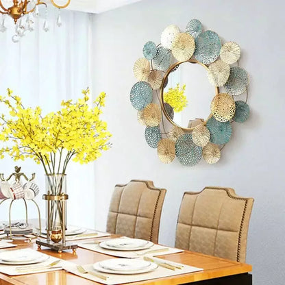 Decorative wall mirror with floral design above a dining table set.