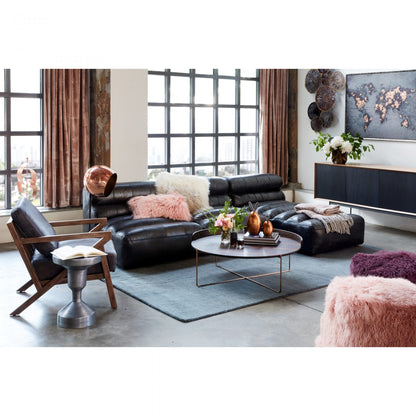 Modern living room with black leather sofa, armchair, and decorative elements.