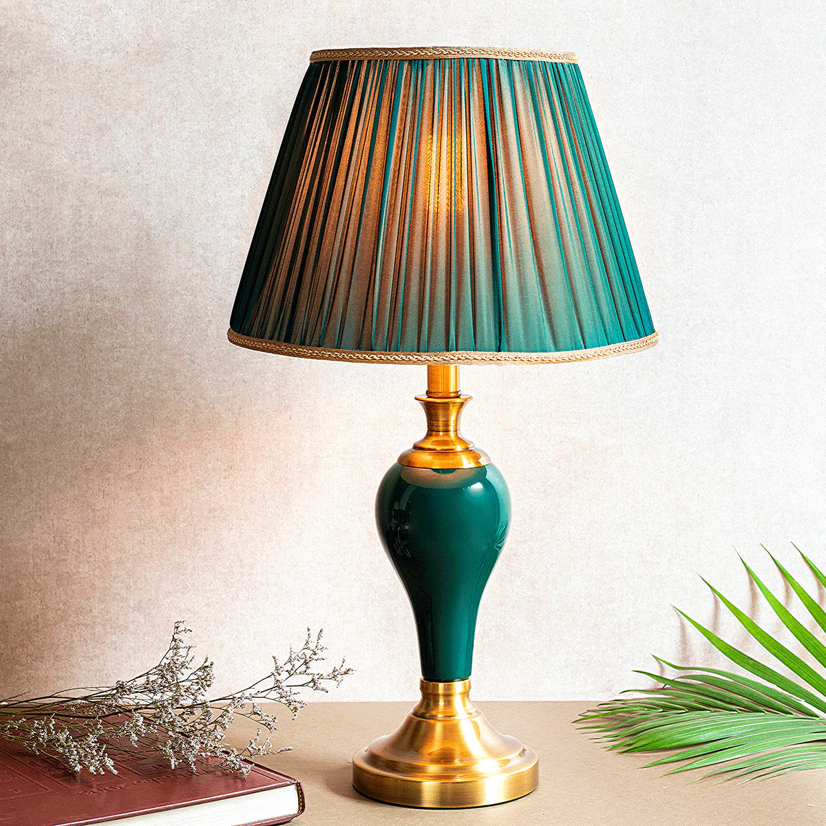 Table lamp with green and gold shade on a neutral background