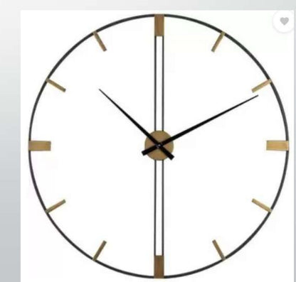 Round wall clock with black and gold design on a white background