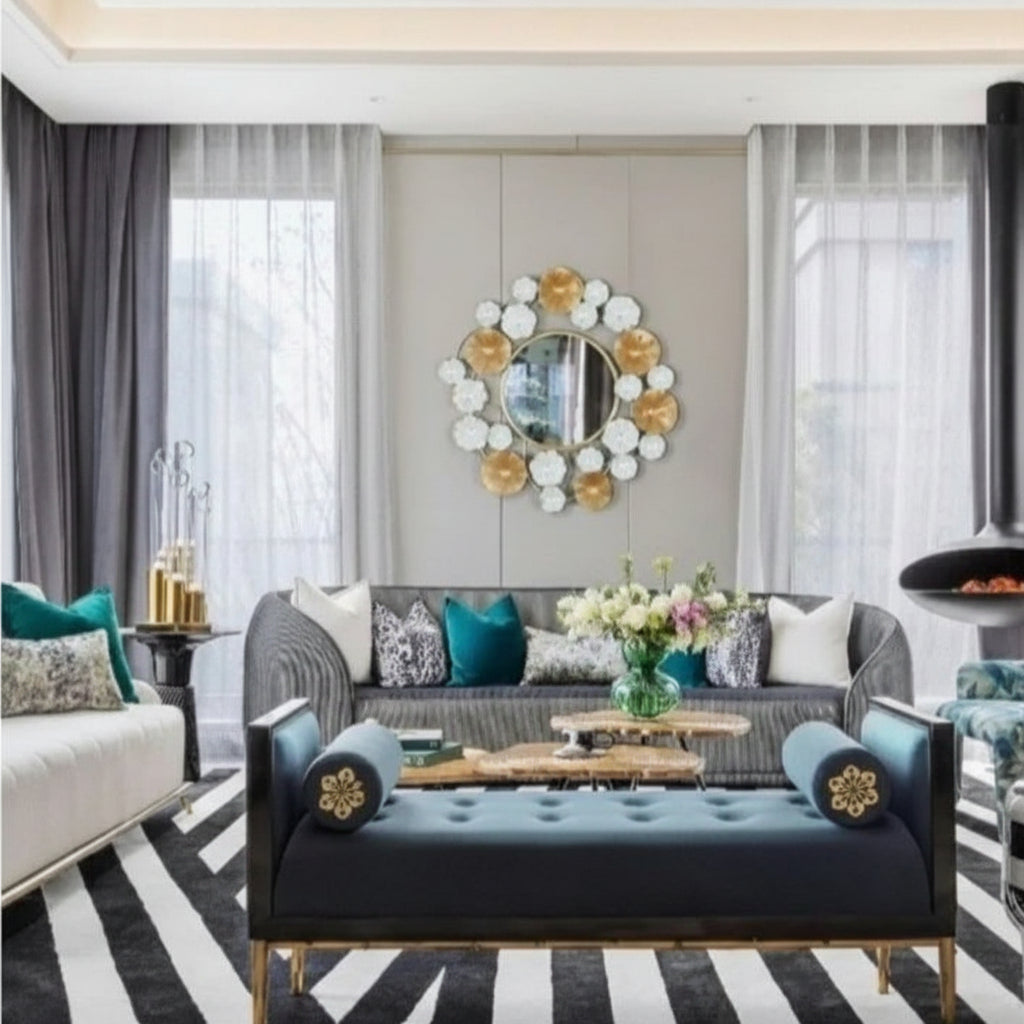 Modern living room with gray sofa, blue bench, and decorative mirror.