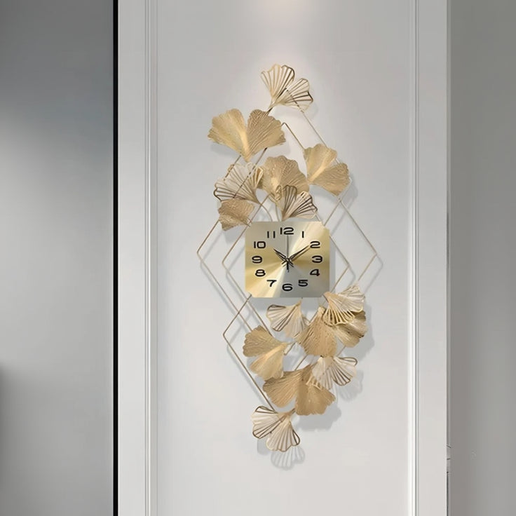Decorative wall clock with gold leaf design on a white background