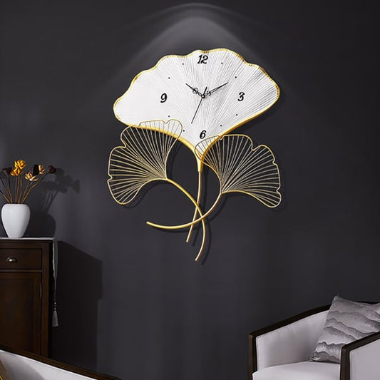 Decorative wall clock with leaf design on a dark wall