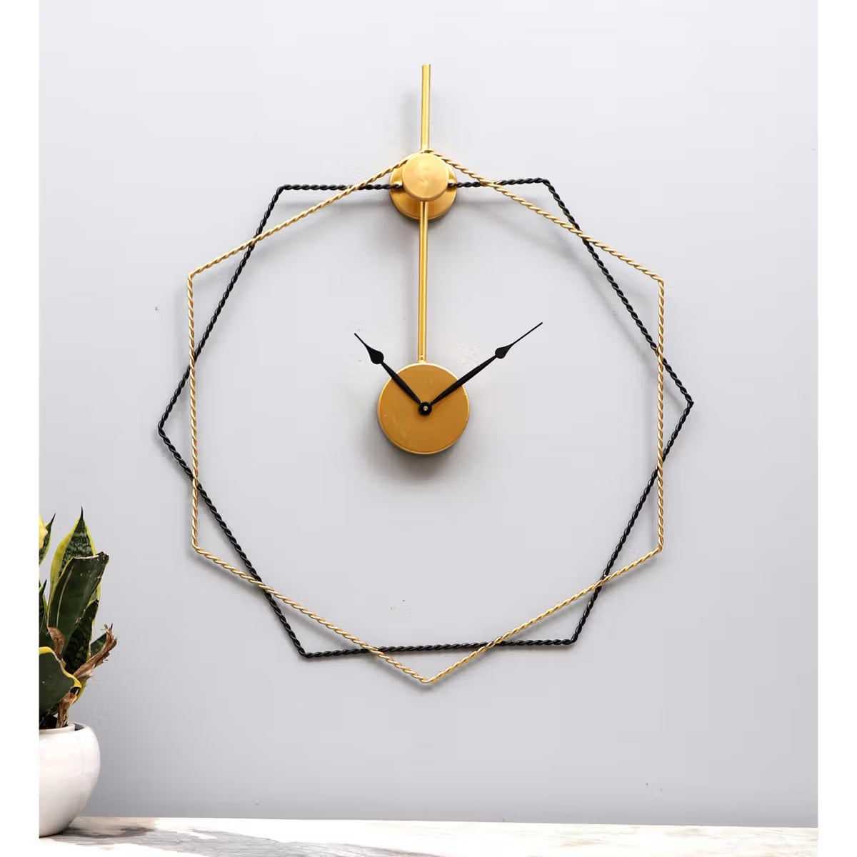 Geometric wall clock with gold and black design on a light gray background