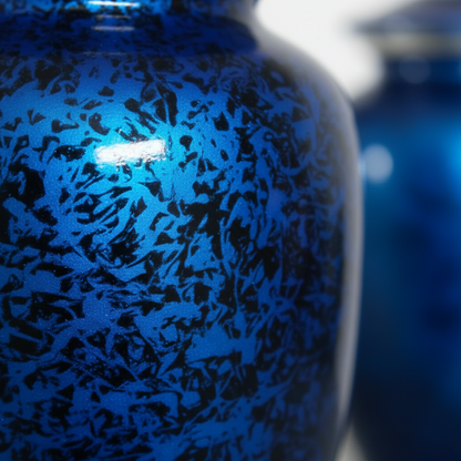 Close-up of a blue ceramic vase with black speckled pattern
