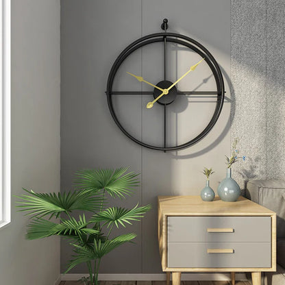 Decorative wall clock on a gray wall with a side table and plant in the foreground.