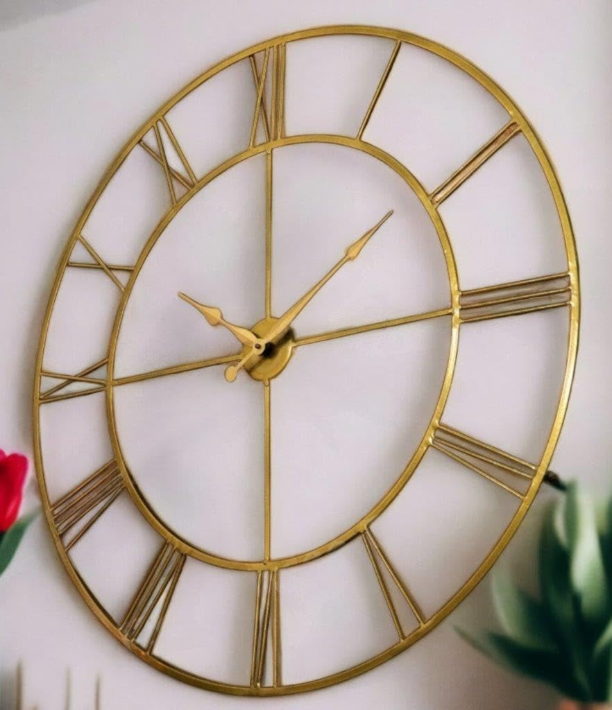Gold wall clock with Roman numerals on a white background